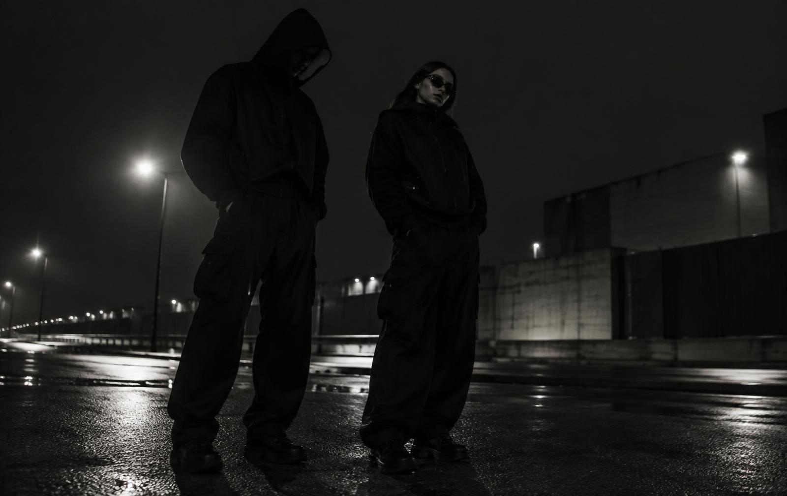 TOP RANK streetwear worn on a wet city street at night